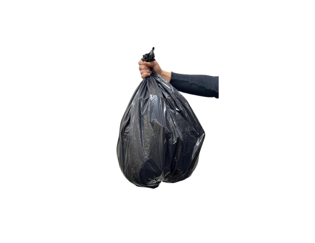 A person holding black bag filled with trash