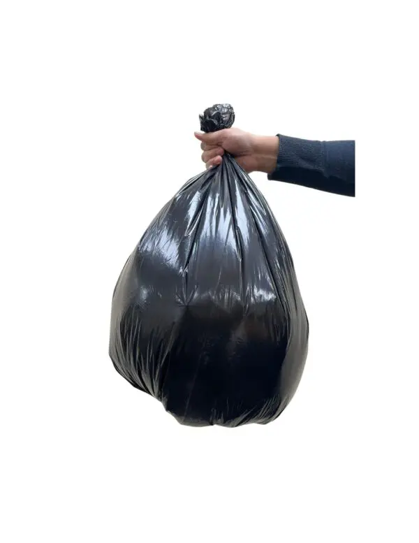 A person hand holding a black bag filled with trash